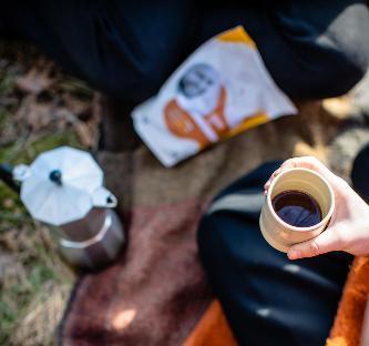 Picknick met Sunny Joe koffie, bialetti en hand die kop vasthoudt