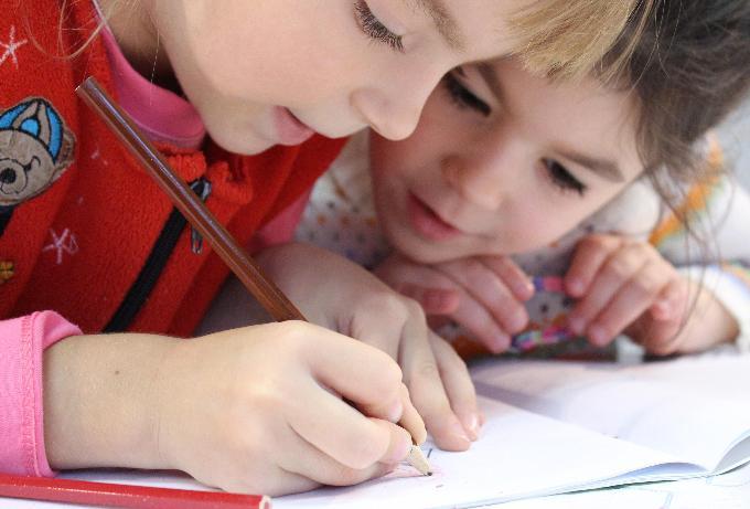 Two children helping each other with a task